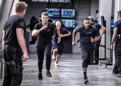 men running in a gym with police officers behind them