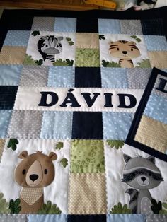 a baby quilt with animals on it and the name david written in large letters,