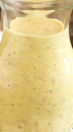 a pitcher filled with yellow liquid sitting on top of a table