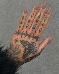 a person's hand with tattoos on it