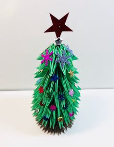 an origami christmas tree with a star on top and flowers all over it