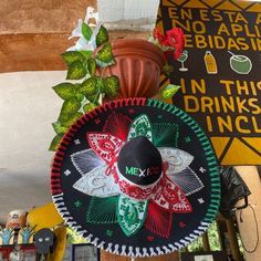 a mexican hat hanging from the side of a wall next to a sign that says in this drinks incl