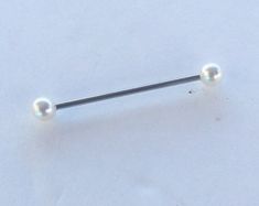 a pair of surgical steel nose studs with two balls on each end in the snow