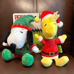 two stuffed animals sitting on top of a brown leather chair next to a sign that says peanuts