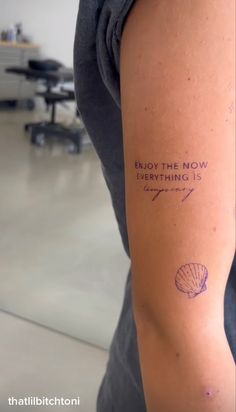 a woman with a tattoo on her arm that says enjoy the now everything is