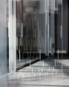 an empty hallway with glass walls and white lines on the floor in front of it