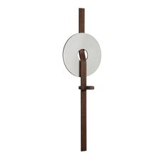 a white and brown object is hanging on the wall next to a pole with a circular mirror