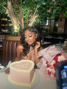 a woman sitting at a table in front of a cake