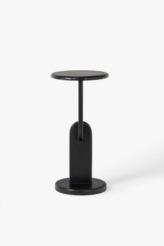 a small black table with a round top and metal base on an isolated white background