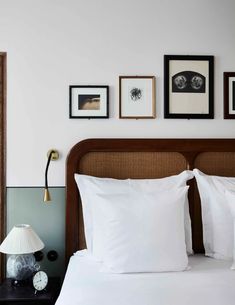 a bed with white pillows and pictures on the wall