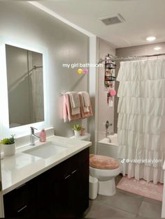 a bathroom with a sink, toilet and shower curtain in it's center area