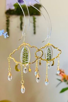 These modern minimalist plant earrings are made with resin, for a statement earring that you will love. Made from Non-toxic Resin and real dried botanicals that were carefully selected to make this set unique and perfect for daily use. Crystals are glass. SIZE : 3.5in Length X 2.5in Width MATERIAL USED: Non-Toxic Epoxy Resin, Brass Frame, Hypoallergenic Hoops, Dried Flowers, botanicals, terrariums. CARE: Don't store in high heat, which can cause shape defects and flowers to fade. Due to the jewe Handmade Leaf-shaped Botanical Earrings, Handmade Botanical Leaf Earrings, Botanical Pressed Flowers Dangle Earrings, Dried Botanicals, Plant Earrings, Hand Making, Statement Earring, Brass Frame, Making Jewelry