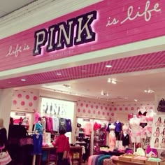 the inside of a pink store with clothes on display and signs that read, life is a pink is life