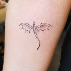 a small dragon tattoo on the arm