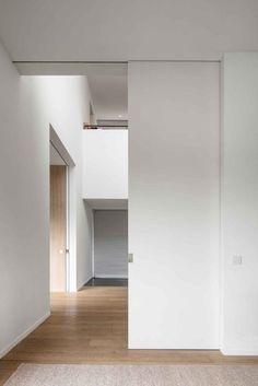 an empty room with wooden floors and white walls