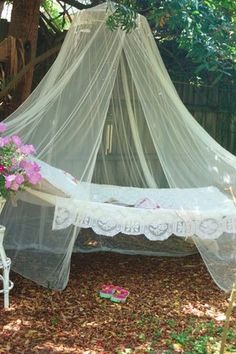 a white bed sitting in the middle of a forest