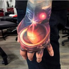 a man's hand with a tattoo on it that has an image of a person holding