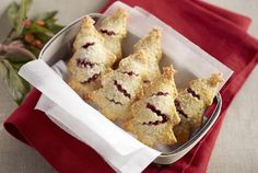 a tin filled with pastries sitting on top of a red napkin