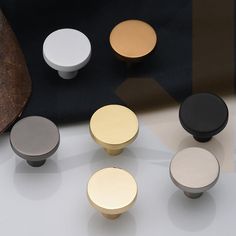 several different types of knobs and handles on a white counter top with a black background