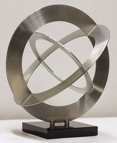 a metal sculpture sitting on top of a wooden stand