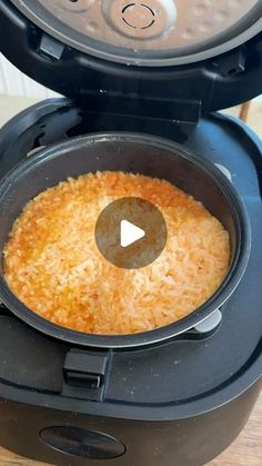 an air fryer with rice in it sitting on a table