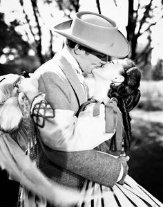 a man in a hat kissing a woman on the cheek