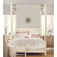 a white bed sitting in a bedroom next to a dresser