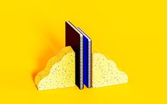 two books on top of each other in front of a yellow background with black and blue pages