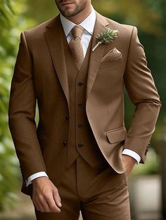 a man in a brown suit with a flower on his lapel is posing for the camera