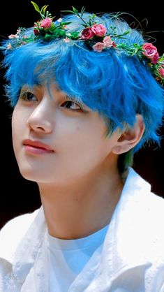 a young man with blue hair and flowers in his head wearing a flower crown on top of his head