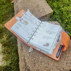 an open notebook sitting on top of a rock