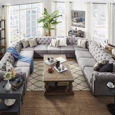 a living room filled with lots of couches and tables in front of large windows