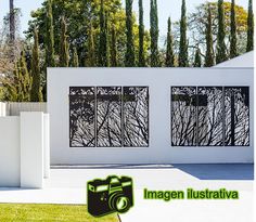 a white house with trees in the background and an image of a camera next to it