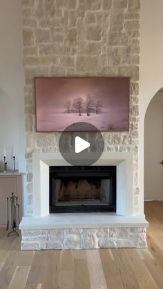 a living room with a fire place and stone fireplace mantel in front of a painting on the wall