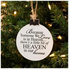 a christmas ornament hanging from a tree with the words because someone we love is in heaven there's a little bit of heaven in our home