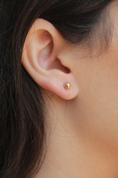 "These tiny simple 14k Gold Filled round ball earrings are easy wearing, unisex, and classic for everyday wear. Suitable with any outfit or occasion. Ideal for everyday wear and safe to get wet! The round dot minimalist earrings comes with BOTH gold Filled butterfly backs and soft clear silicon comfort backs. The comfort backs are great for second holes, first earrings, and for those that just prefer them. The circle shape is a universal symbol represents the notions of totality, wholeness, orig Top Earrings Gold Indian, Small Gold Stud Earrings, Ear Studs Indian Gold For Women, Baby Studs Earrings Gold, Simple Gold Earrings Indian, Gold Studs Earrings Indian Round, Baby Earrings Gold Indian, Small Gold Earrings Indian, Ear Tops Gold Indian