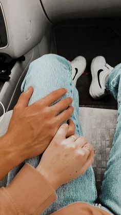 two people sitting in the back seat of a car with their hands on each other's legs