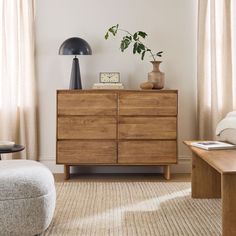 a wooden dresser sitting next to a window in a living room