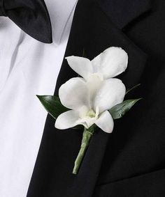 a boutonniere with white flowers on it is worn by a man in a tuxedo