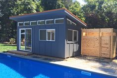 a backyard shed next to a swimming pool