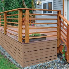 a wooden deck next to a house with plants growing on the top and bottom steps