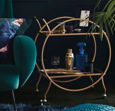 a blue chair sitting next to a table with bottles and glasses on it