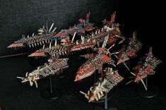 a group of small model ships sitting on top of each other in front of a black background