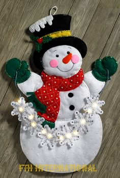 a snowman ornament is shown on a wooden floor with the words home and garden essentials