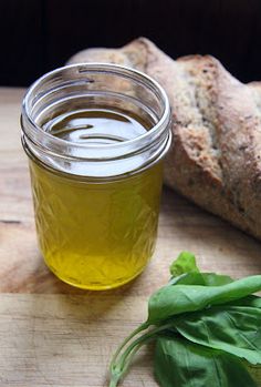 a glass jar filled with liquid next to bread