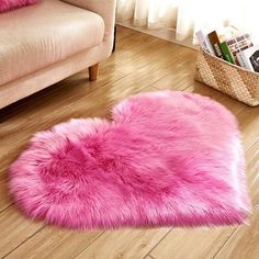 a pink heart shaped rug sitting on top of a wooden floor