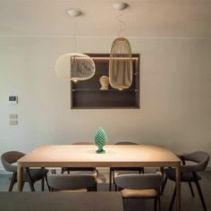 a dining room table and chairs in front of a painting hanging on the wall above it