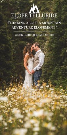 a man and woman standing in the middle of a field with wildflowers on it