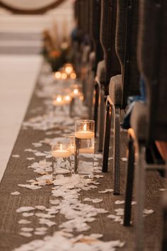 rows of pews with candles and flowers on them