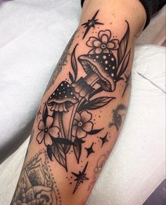 a woman's arm with tattoos on it and flowers in the middle of her arm